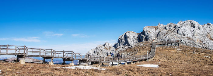 Metallic structure on rock against blue sky