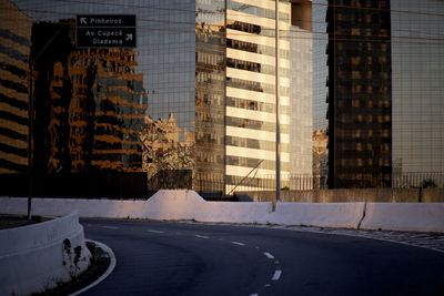 Road by buildings in city during sunset