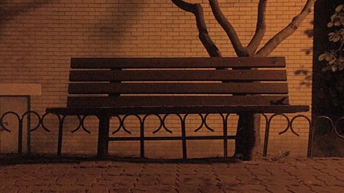 Empty bench against wall