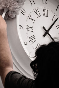 Midsection of man holding clock