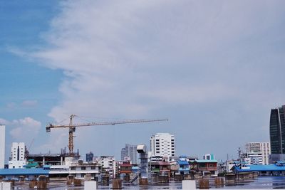 Construction site by buildings against sky
