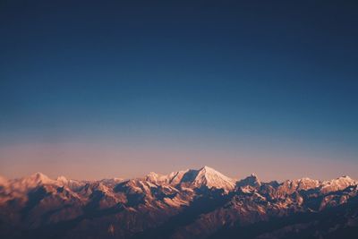 Scenic view of snowcapped mountains against clear blue sky