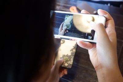 Close-up of woman photographing phone cover