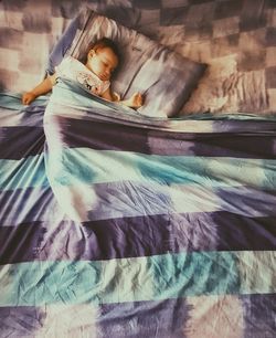 Boy sleeping on bed at home