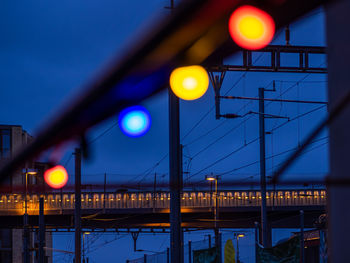 Illuminated bridge against sky at night