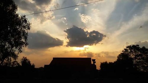 Silhouette of building against cloudy sky