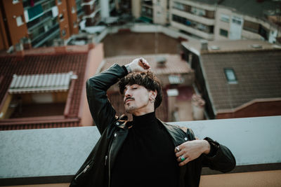 Portrait of young man looking at city buildings