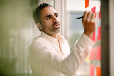 Businessman writing on adhesive note at convention center