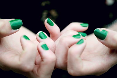 Cropped hands of woman with green nail polish