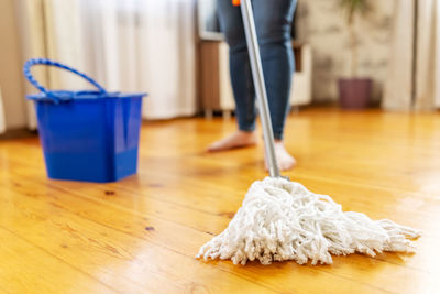 Low section of person with towels on hardwood floor at home