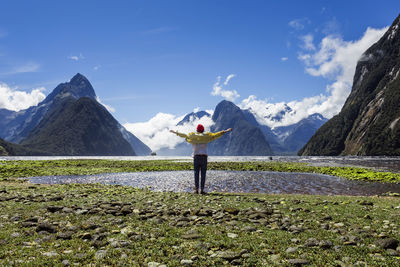 Man standing on snowcapped mountain against sky