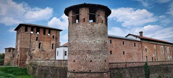 Low angle view of old building against cloudy sky