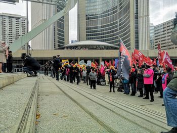 People on street against buildings in city