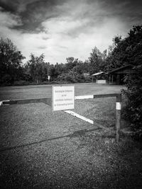 Information sign on landscape against cloudy sky