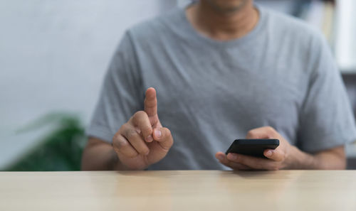 Midsection of man using mobile phone