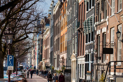 People on street amidst buildings in city