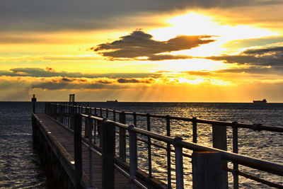 Pier on sea at sunset