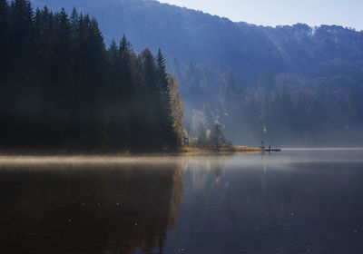 Scenic view of lake by trees against sky