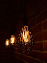 Illuminated light bulbs hanging on wall at home