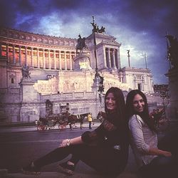 Tourists in front of building against sky