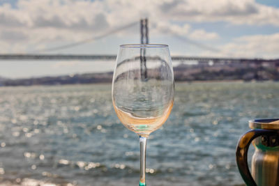 Close-up of wine glass on table against sky