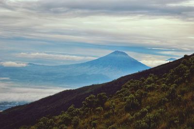 Scenic view of mountains against cloudy sky