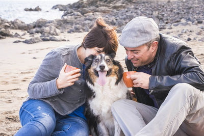 Couple with dog relaxing on beach