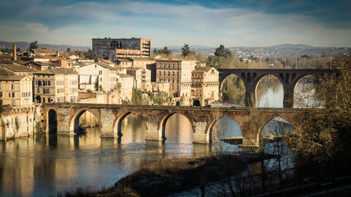 Arch bridge over river against sky