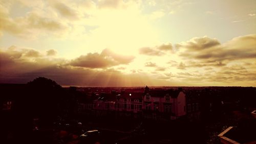 High angle view of silhouette buildings against sky during sunset