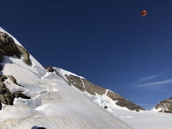 Scenic view of snowcapped mountains against clear blue sky