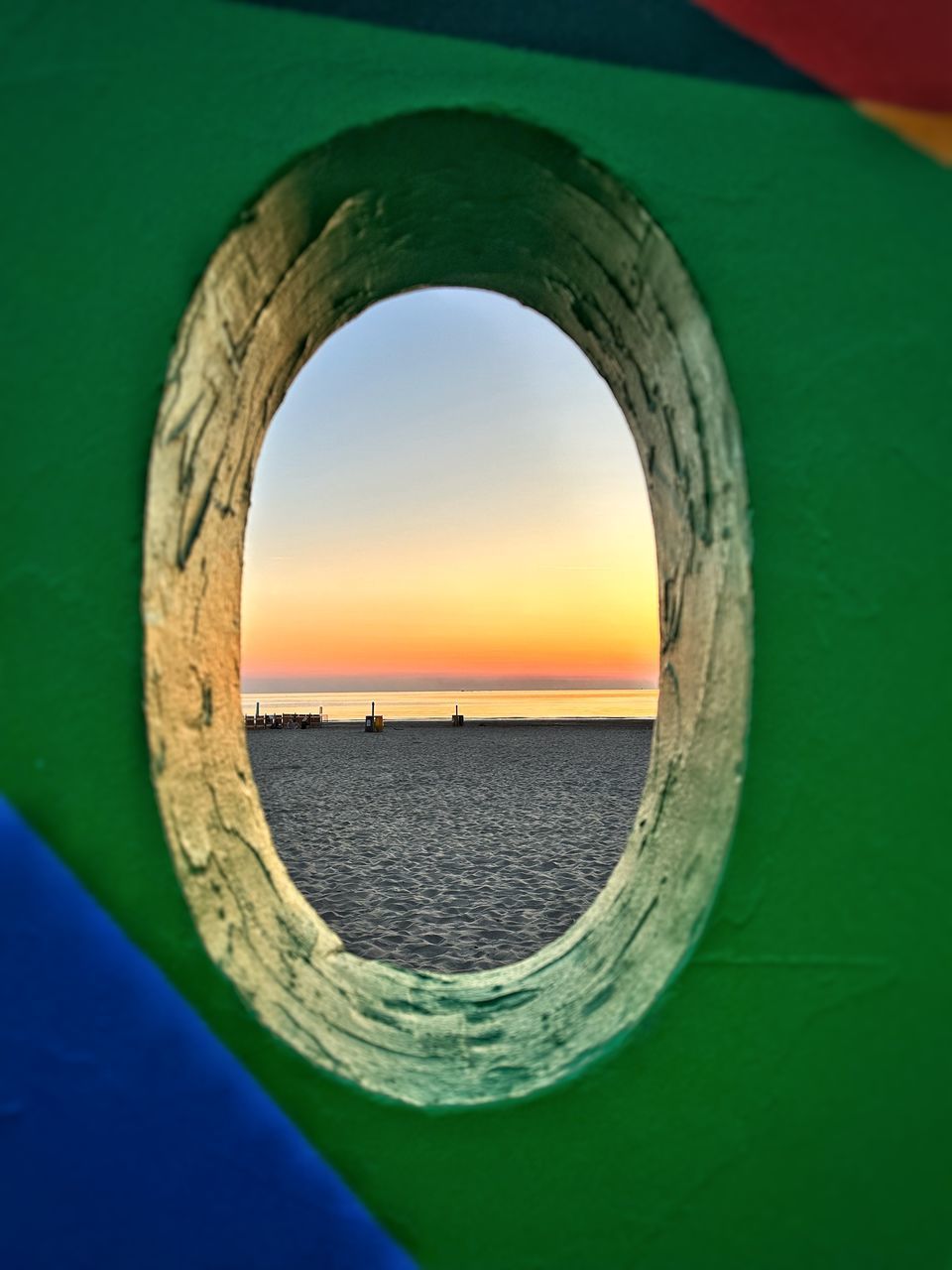 green, blue, water, sky, circle, sea, geometric shape, reflection, yellow, nature, shape, no people, architecture, light, outdoors, sunlight, hole, scenics - nature, porthole, day, tranquility, built structure, sunset, land, nautical vessel, arch, beauty in nature