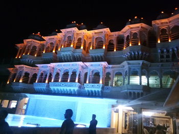 People in illuminated building at night