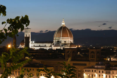 Illuminated buildings in city against sky