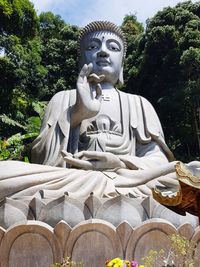 Low angle view of statue against trees