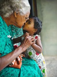 Senior woman kissing granddaughter