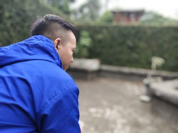 Side view of man sitting in park