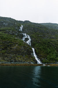 Scenic view of waterfall against sky