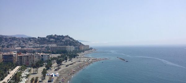 Aerial view of buildings by sea against sky