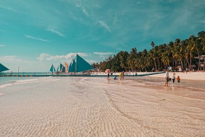 People at beach against sky