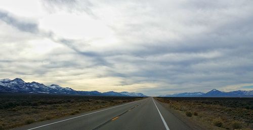 Country road against cloudy sky