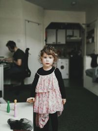 Portrait of cute girl standing at home