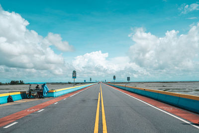 Empty road against cloudy sky