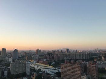 Aerial view of buildings in city against clear sky