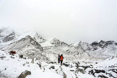 Tourists on snow covered mountain