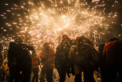 People watching firework display at night