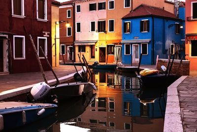 Boats moored by houses in city