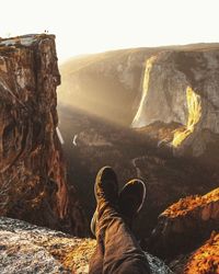 Low section of man on mountain against sky