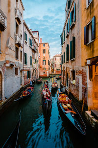 Typical venetian canal crowded with gondolas crossing it