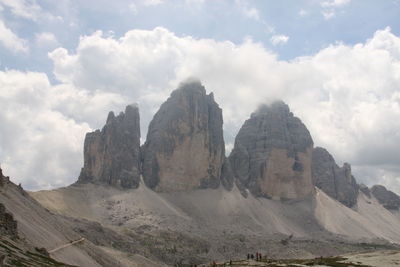 View of rocky mountains against cloudy sky