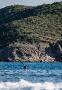 Man surfing on rock in sea